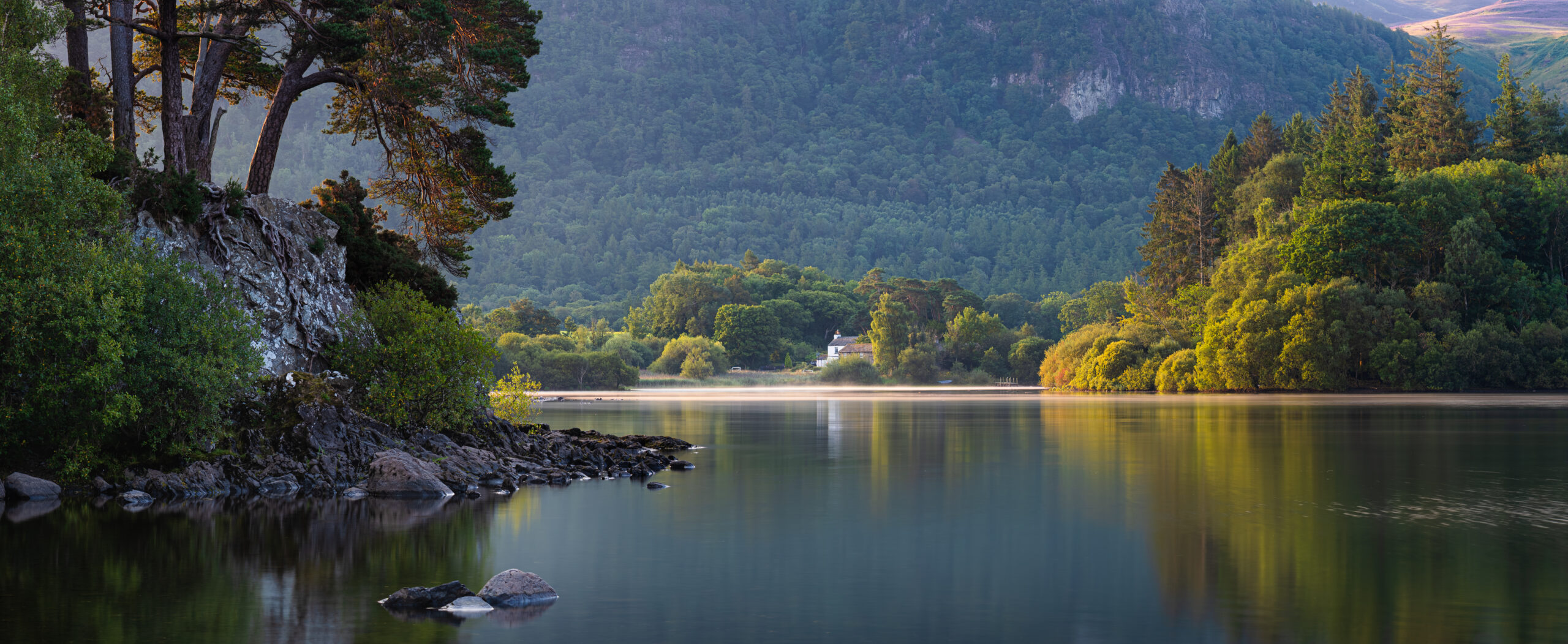 A calm, still lake reflecting the surrounding landscape